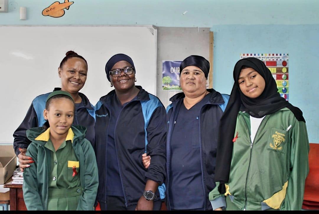 IPI care workers with learners wearing red awareness ribbons during a school health awareness session in Cape Town